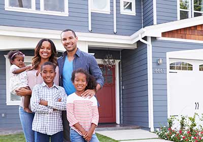 Insured family in front of home