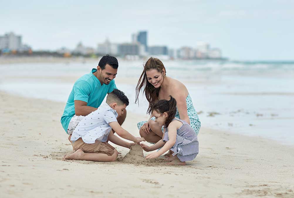 Family at beach building sandcastle in Florida