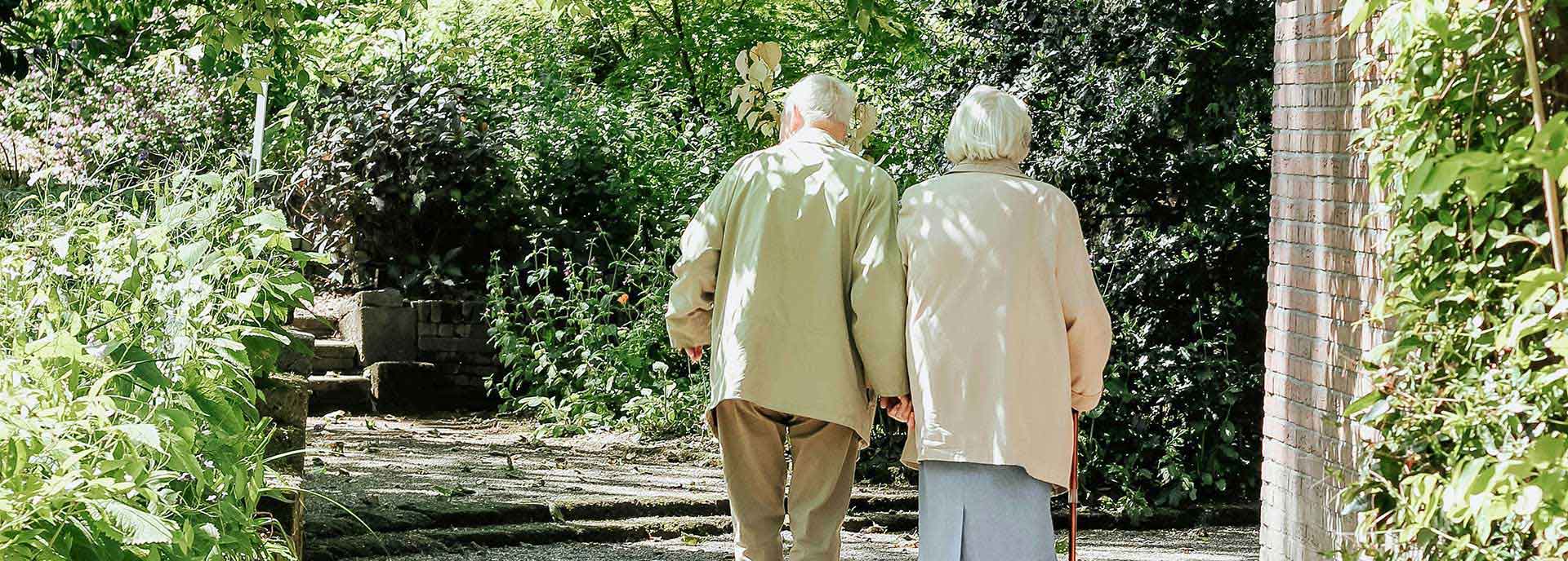 Agent explaining medicare insurance plans Elder couple holding hands walking