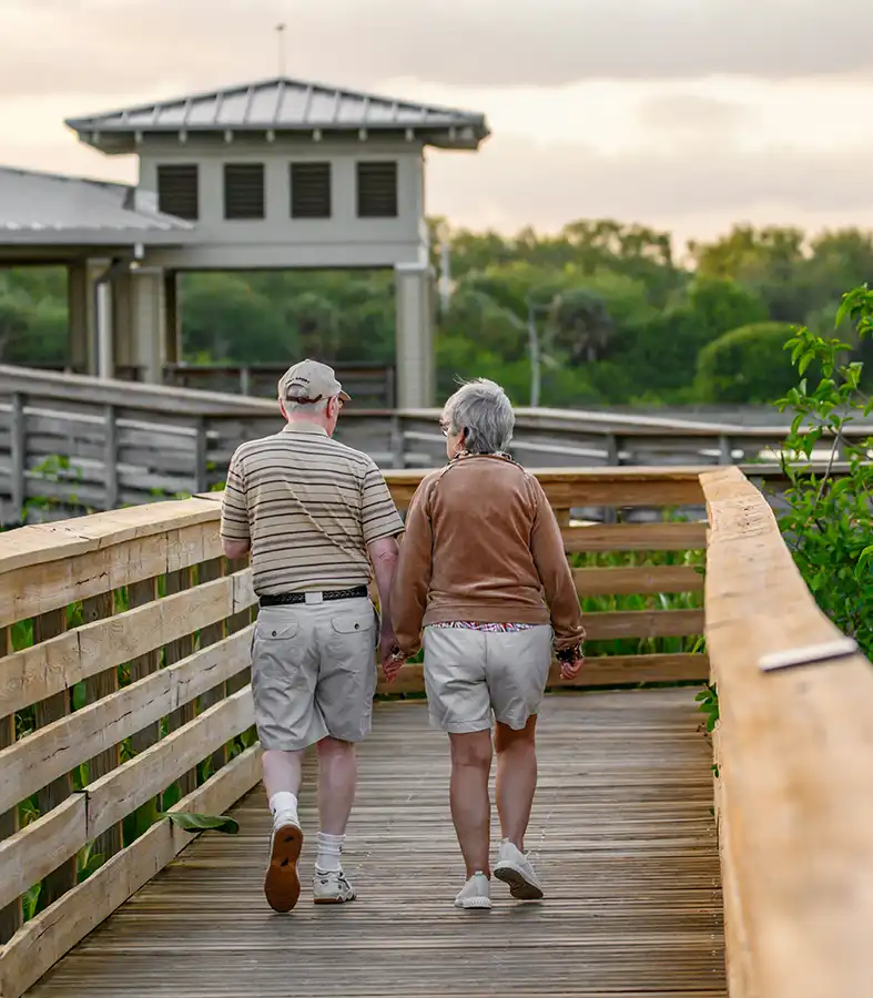 Older couple walking in Florida on beach board walk