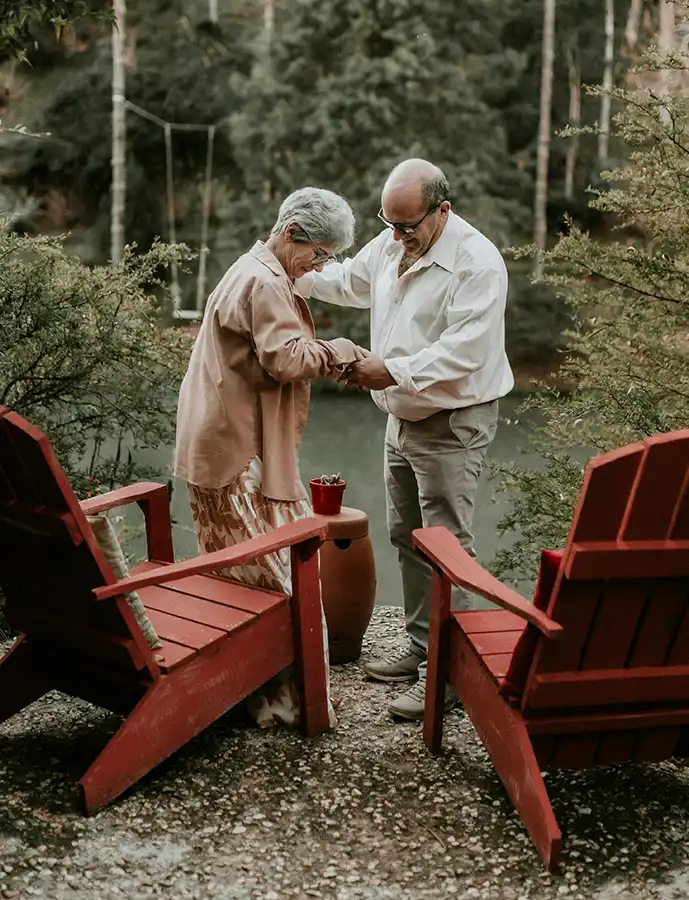 Older couple helping site in Adirondack chair